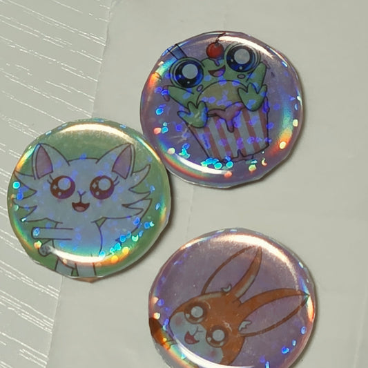 Three colorful buttons with cartoon designs on a light gray background