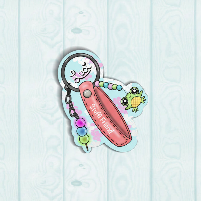 small green frog charm hanging on a pink bracelet keychain