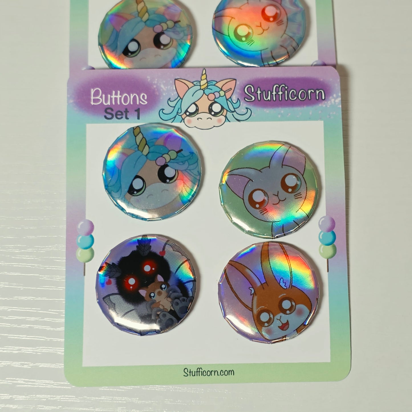 Set of colorful buttons with cartoon designs on a display card.